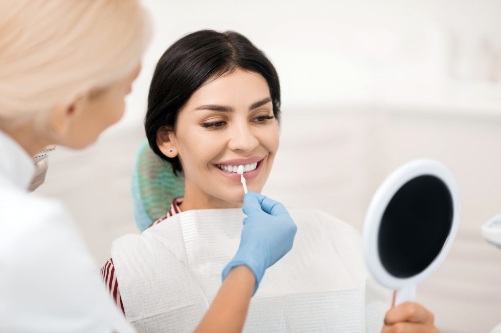 Woman trying on teeth whitening sample at dentists